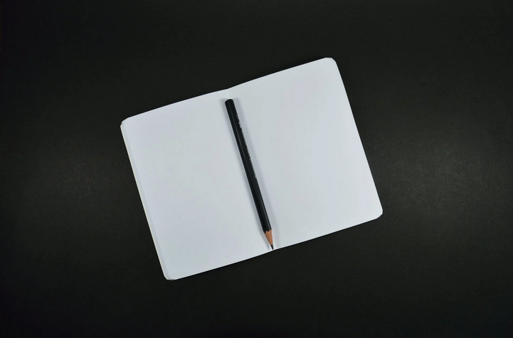 an open book and pencil